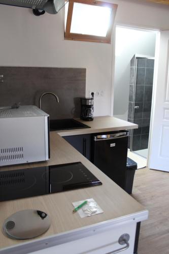 a kitchen with a counter top with a computer on it at Studio neuf proche d'Alençon et Le mans in Lonrai