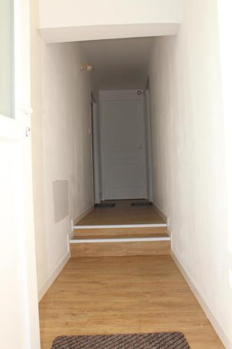 an empty hallway with stairs leading to a door at Studio neuf proche d'Alençon et Le mans in Lonrai