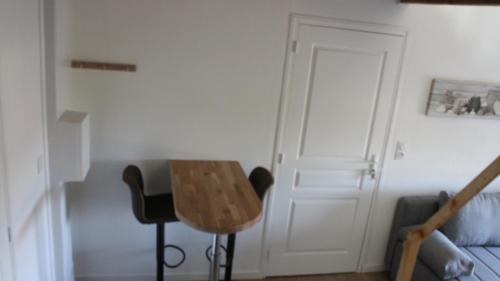 a living room with a table and a couch at Studio neuf proche d'Alençon et Le mans in Lonrai