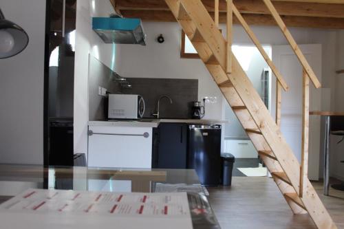 uma cozinha com uma mesa de vidro num quarto em Studio neuf proche d'Alençon et Le mans em Lonrai