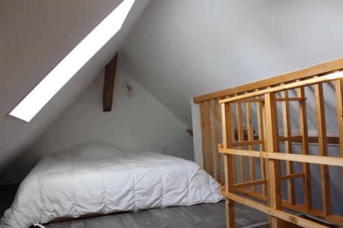 um quarto com uma escada e uma cama no sótão em Studio neuf proche d'Alençon et Le mans em Lonrai