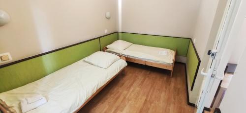 two beds in a room with green and white at Strzeszynek - wypoczynek in Poznań