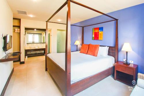1 dormitorio con cama con dosel y almohadas de color naranja en Fabulous Playa Getaway at 38th and Beach plus 2 Pools Onsite, en Playa del Carmen