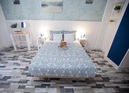 sypialnia z łóżkiem z niebieską kołdrą w obiekcie Fuencarral Adeco w Madrycie