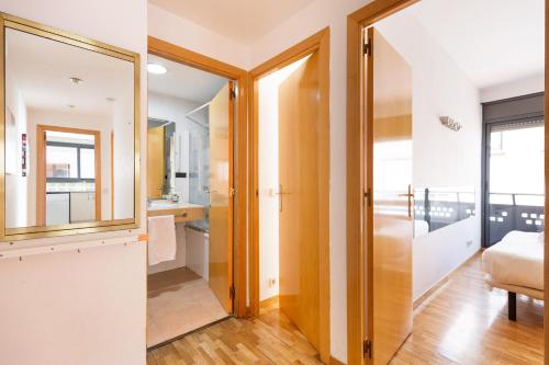 Habitación con espejo y dormitorio con cama. en Stay U-nique Apartments Bonsoms, en Barcelona