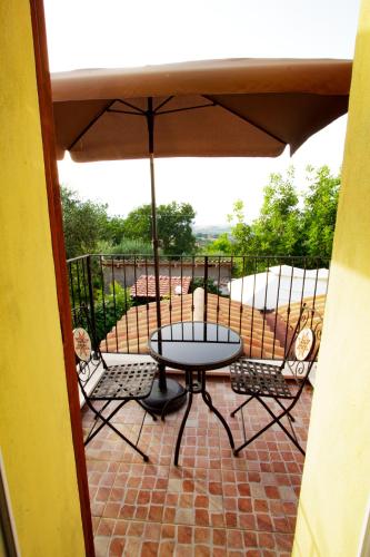 a table and chairs on a patio with an umbrella at Eden Lilli B&B in La Pieve