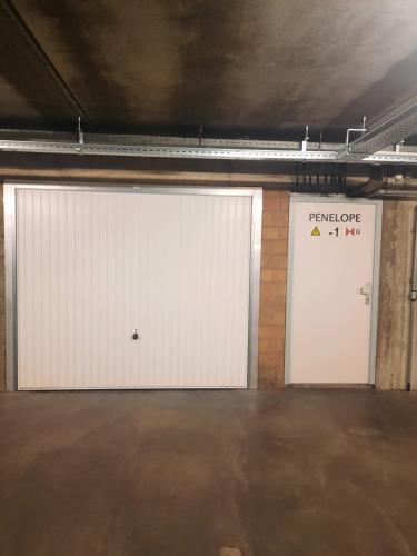 two white garage doors in a parking lot at Zeezicht Sibeac Koksijde in Koksijde