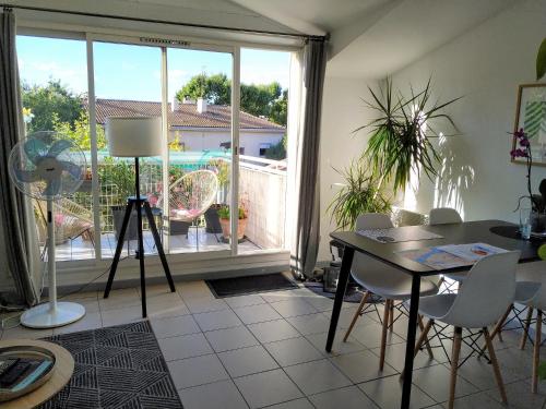 un salon avec une table et des chaises et une fenêtre dans l'établissement Charming Duplex with Terrace Historical City Center, à Arles