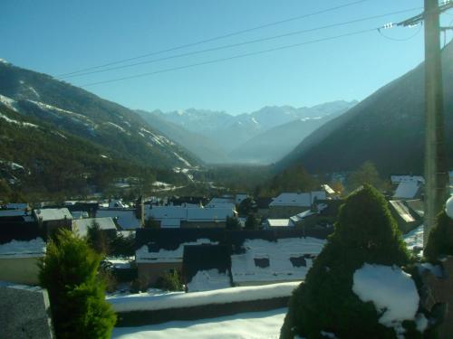 a view of a town with mountains in the background at Maison des trois ormeaux in Cier-de-Luchon