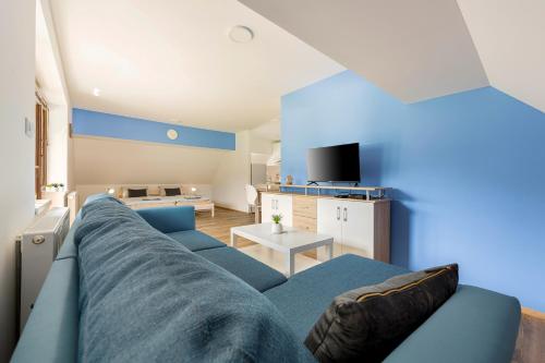 uma sala de estar com um sofá azul e uma mesa em Apartmaji Rupnik em Bohinjska Bistrica