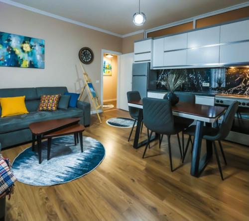 a living room with a blue couch and a table at Edea's Apartment in Korçë