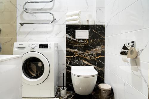 Un baño con lavadora y un inodoro. en Old Town Cat Apartment, en Klaipėda