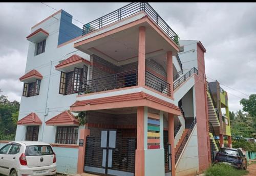 un edificio con un coche aparcado delante de él en Akshay Sweet Home Stay en Mysore