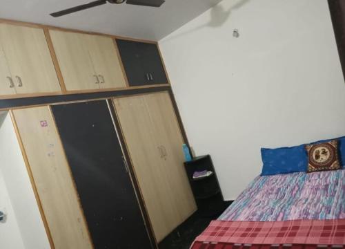 a bedroom with lockers and a bed in a room at Akshay Sweet Home Stay in Mysore