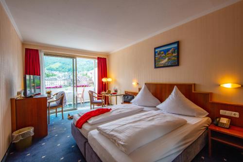 ein Hotelzimmer mit großem Bett und Balkon in der Unterkunft Moselstern Hotel Brixiade &Triton in Cochem