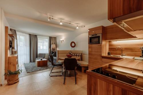 a kitchen and living room with a table and chairs at Ferienwohnungen Renberg in Maria Alm am Steinernen Meer