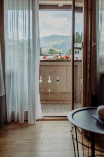 a room with a window with a table and a view at Ferienwohnungen Renberg in Maria Alm am Steinernen Meer