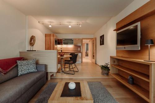 a living room with a couch and a tv and a table at Ferienwohnungen Renberg in Maria Alm am Steinernen Meer