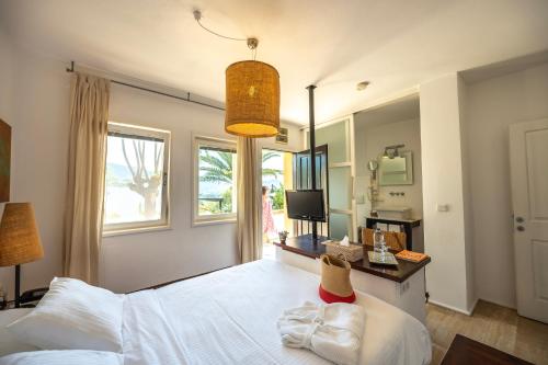 a bedroom with a white bed and a window at 4reasons hotel + bistro | 12+ in Yalıkavak