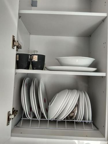 a kitchen with white plates and bowls on shelves at Stavroulis' Maisonette in Mokhós