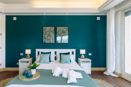 a bedroom with a large bed with a blue wall at Ostia Holiday Boutique SPA in Lido di Ostia