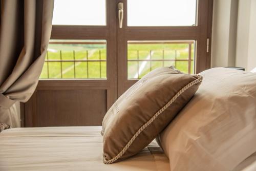 a pillow sitting on a bed in front of a window at Montalbera Wine Suites in Montemagno