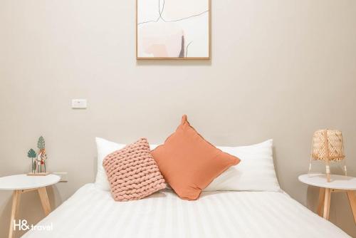 a bedroom with a bed with pillows on it at Taitung Puyuma Style Inn in Taitung City