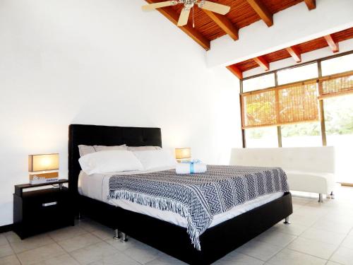 a bedroom with a bed in a room with windows at 5E Hotel Boutique in Girardot