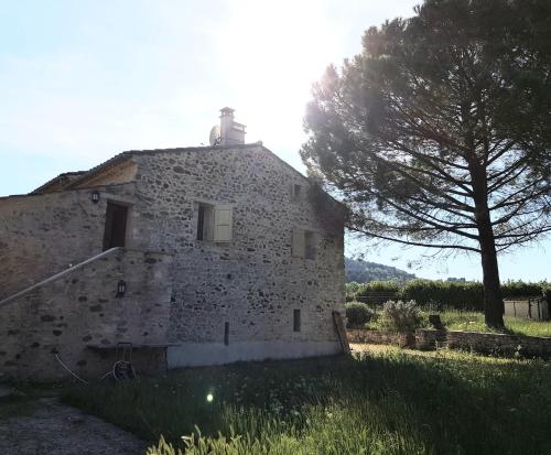 un ancien bâtiment en pierre dans un champ avec un arbre dans l'établissement La Croix du Sud - Ocres en Provence, à Apt