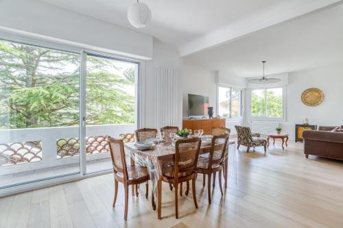 une salle à manger et un salon avec une table et des chaises dans l'établissement Villa Le Deck - Grande maison familliale proche plage, à Arcachon