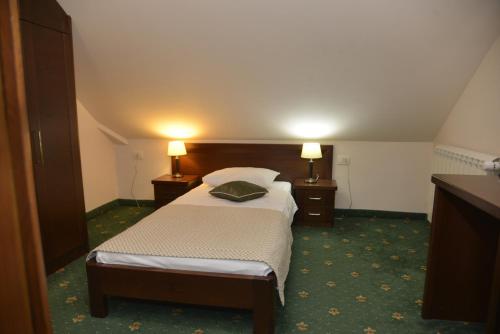 a hotel room with a bed and two lamps at Hotel Trebjesa in Nikšić