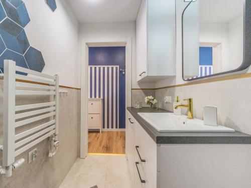 uma casa de banho com um lavatório e um espelho em Glow Apartments, Apartament Długa 69 em Gdansk