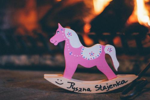 a pink plastic horse on a wooden toy boat at Pyszna Stajenka in Bąków