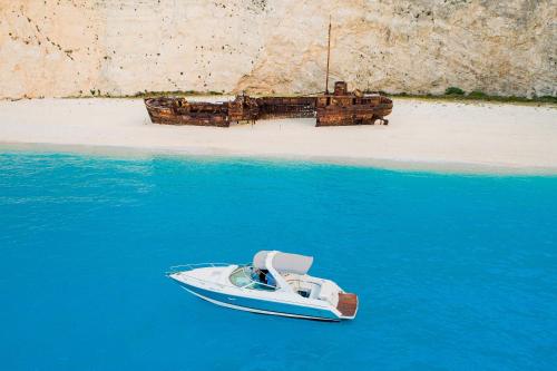 a small boat in the water next to a beach at Katoi traditional house in Éxo Khóra