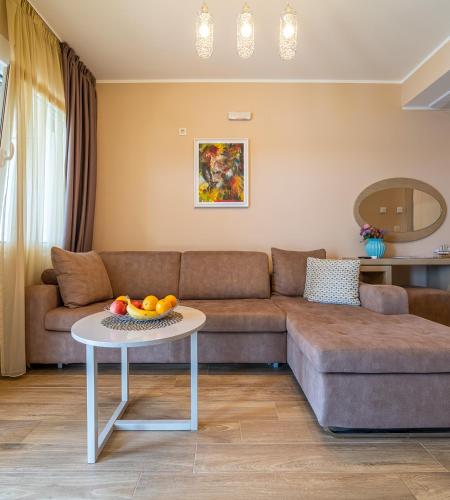 a living room with a couch and a table with fruit on it at Elysium Tivat in Tivat