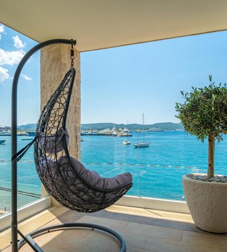 a hammock in a room with a view of the water at Elysium Tivat in Tivat