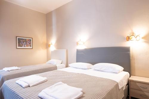 two beds in a room with white pillows at Yannis Hotel in Krinídhes