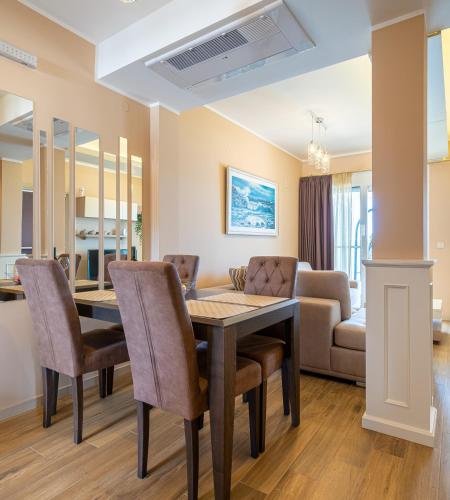 a dining room and living room with a table and chairs at Elysium Tivat in Tivat