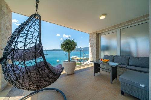 a hammock in a living room with a view of the ocean at Elysium Tivat in Tivat