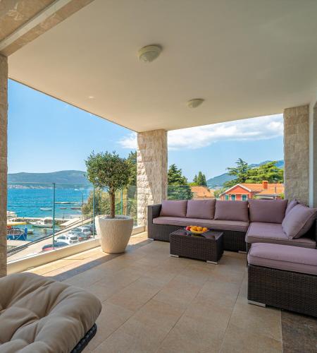 a living room with purple couches and a large window at Elysium Tivat in Tivat