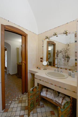 a bathroom with a sink and a mirror at Umbra Idris Holiday Home in Matera