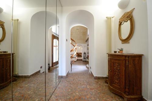 a hallway with a glass door and a mirror at Umbra Idris Holiday Home in Matera