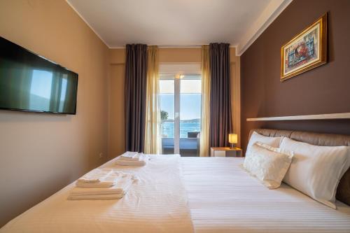 a bedroom with a large bed with a television on the wall at Elysium Tivat in Tivat