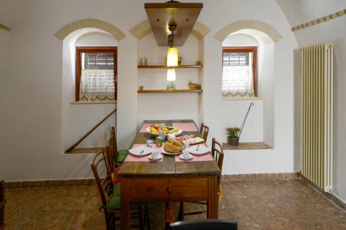 a dining room with a table with food on it at Umbra Idris Holiday Home in Matera