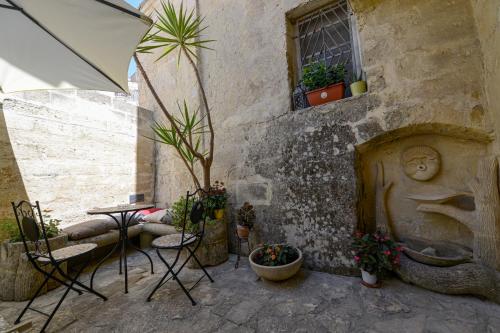 a patio with a table and chairs and plants at Umbra Idris Holiday Home in Matera