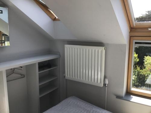 a attic room with a bed and a window at Coachhouse in St Ives