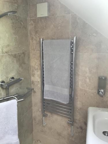 Baño con toallero junto a un lavabo en Coachhouse, en St Ives