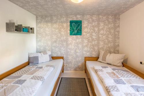 two twin beds in a room with a wall at Ferienwohnung Holl-Horn in Gaienhofen