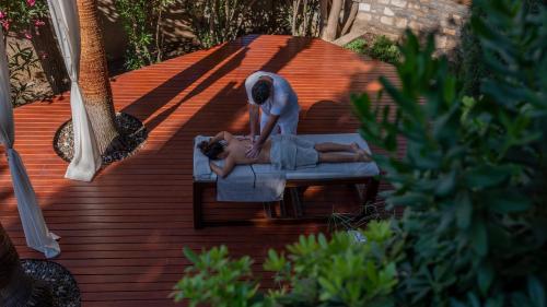 a woman laying on a bench on a deck at 4reasons hotel + bistro | 12+ in Yalıkavak