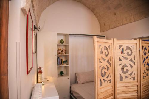 um pequeno quarto com uma cama e uma estante de livros em Casa del sole em Ceglie Messapica